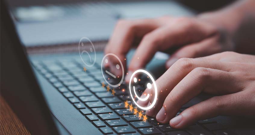 person typing on laptop keyboard with star ratings graphics on top