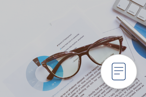 A pair of eyeglasses rests on printed charts and a keyboard, with a pen nearby—capturing the essence of Real World Data. A blue icon of a document is overlaid in the lower right corner.