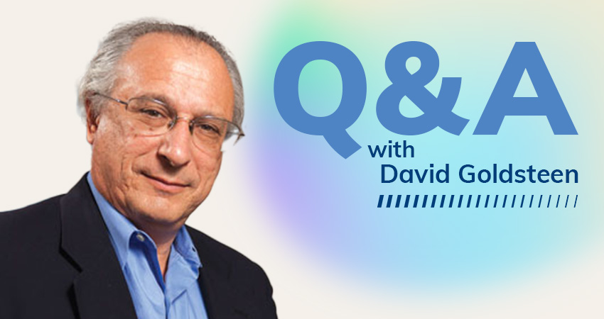 A man with gray hair and glasses wearing a dark blazer and light blue shirt stands next to large blue text that reads Q&A with David Goldsteen on a light background, discussing patient safety with a gradient glow behind them.