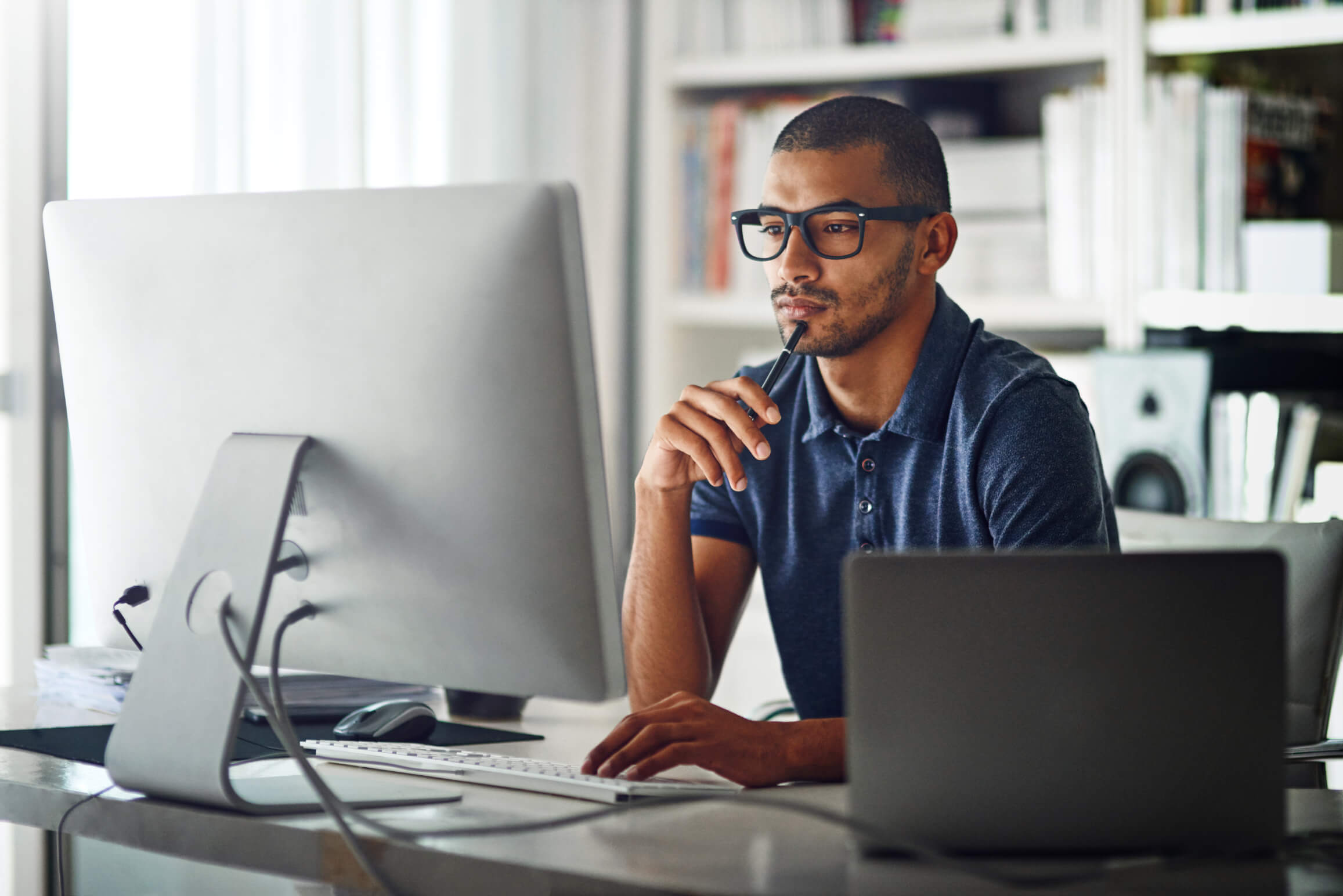 man with glasses using his computer