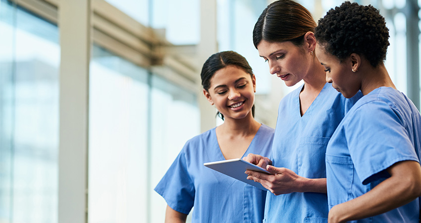happy nurses looking at a tablet