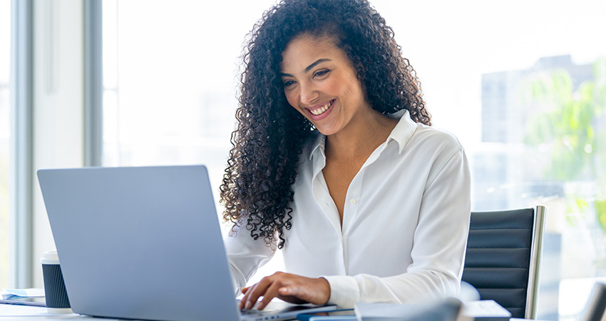 smiling woman looking at a laptop