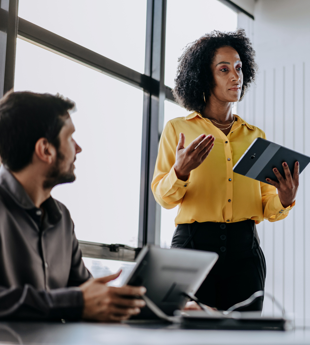 woman presenting in front of male colleague at work conference room