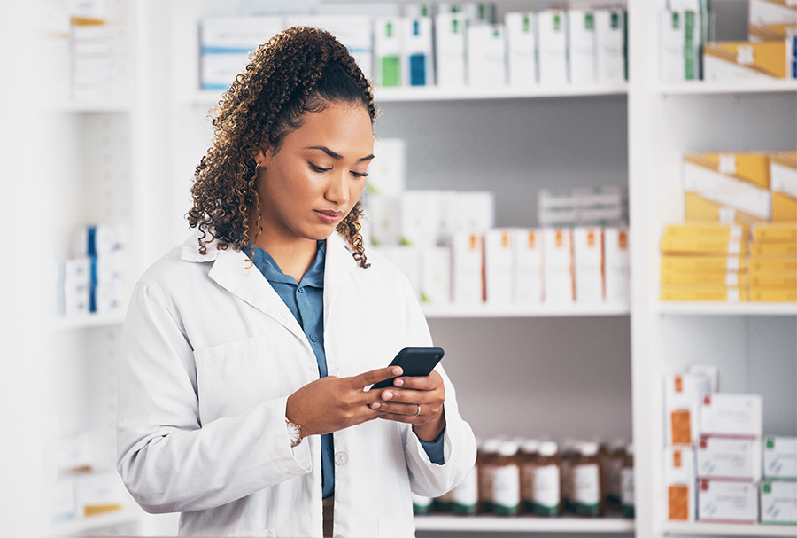 pharmacist using mobile device at pharmacy