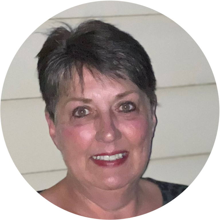 Glenda Hull headshot - woman with pixie cut hair smiling for photo