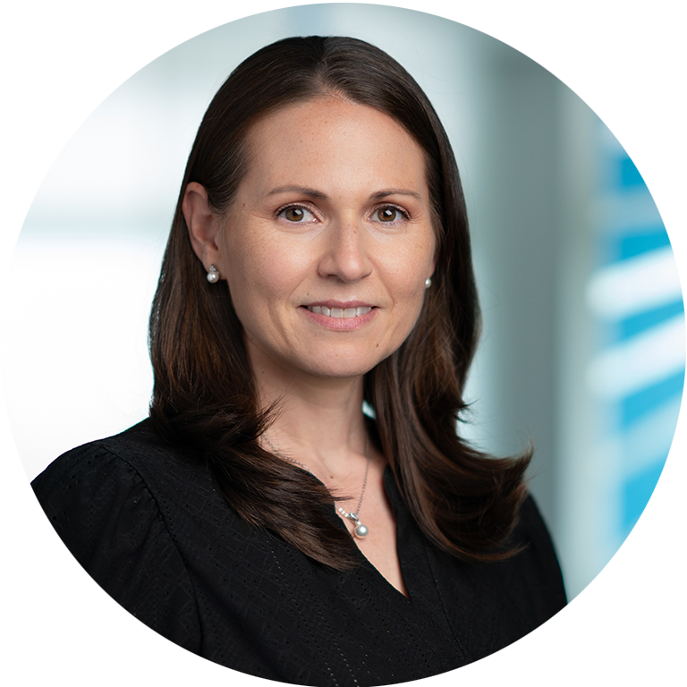 Jennifer Paraschack headshot - woman with dark hair smiling for photo with Inovalon spiral in background